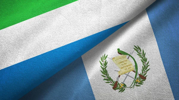 Serra Leoa e Guatemala duas bandeiras de pano têxtil, textura de tecido — Fotografia de Stock