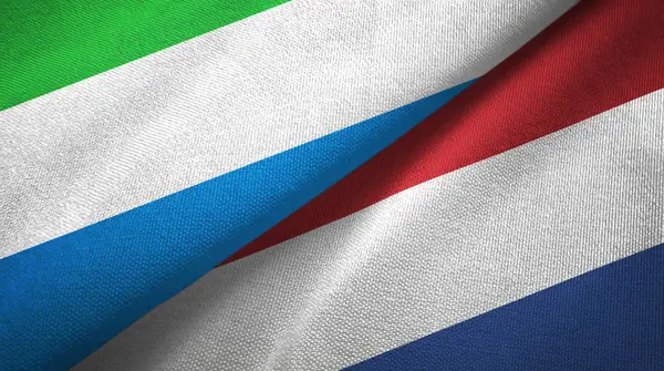 Sierra Leona y Países Bajos dos banderas tela textil, textura de la tela —  Fotos de Stock