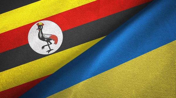 Uganda e Ucrânia duas bandeiras de pano têxtil, textura de tecido — Fotografia de Stock