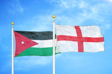 Ürdün ve İngiltere bayrak direğinde iki bayrak ve mavi bulutlu arka plan