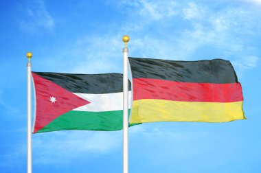 Ürdün ve Almanya bayrak direğinde iki bayrak ve mavi bulutlu arka plan