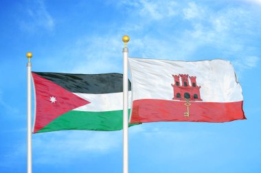 Jordan ve Cebelitarık bayrak direğinde iki bayrak ve mavi bulutlu arka plan