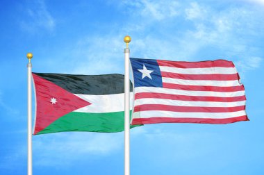 Ürdün ve Liberya bayrak direkleri üzerinde iki bayrak ve mavi bulutlu arka plan