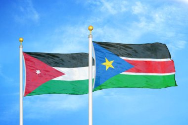 Ürdün ve Güney Sudan bayrak direkleri üzerinde iki bayrak ve mavi bulutlu arka plan