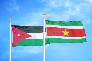 Ürdün ve Surinam bayrak direkleri üzerinde iki bayrak ve mavi bulutlu arka plan