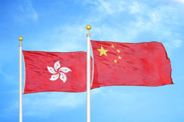 Hong Kong ve Çin bayrak direkleri ve mavi bulutlu arka planda iki bayrak