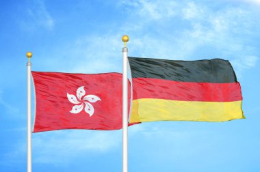 Hong Kong ve Almanya bayrak direkleri ve mavi bulutlu arka planda iki bayrak