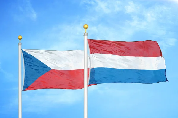 チェコとオランダの旗竿と青空の背景に2つの旗 — ストック写真