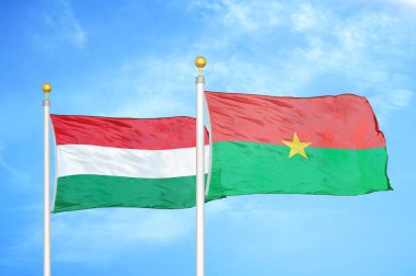 Macaristan ve Burkina Faso bayrak direkleri ve mavi bulutlu arka planda iki bayrak