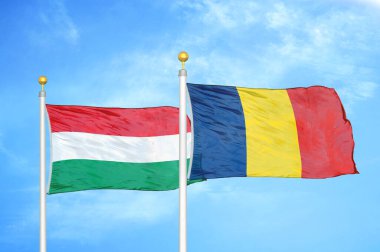 Macaristan ve Çad bayrak direkleri ve mavi bulutlu arka planda iki bayrak