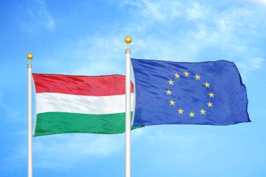 Macaristan ve Avrupa Birliği bayrak direkleri ve mavi bulutlu arka planda iki bayrak