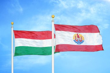 Macaristan ve Fransız Polinezyası bayrak direkleri üzerinde iki bayrak ve mavi bulutlu arka plan