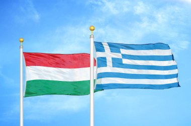 Macaristan ve Yunanistan bayrak direkleri ve mavi bulutlu arka planda iki bayrak