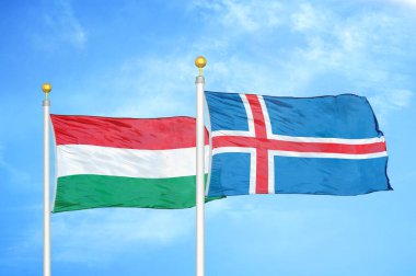 Macaristan ve İzlanda bayrak direkleri ve mavi bulutlu arka planda iki bayrak