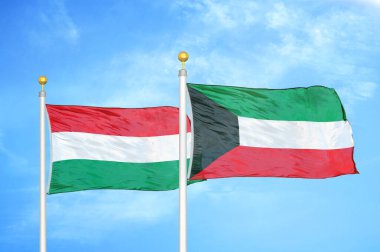 Macaristan ve Kuveyt bayrak direkleri ve mavi bulutlu arka planda iki bayrak