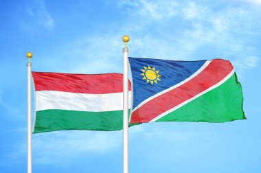 Macaristan ve Namibya bayrak direkleri ve mavi bulutlu arka planda iki bayrak