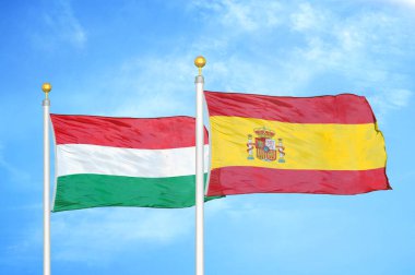 Macaristan ve İspanya bayrak direkleri ve mavi bulutlu arka planda iki bayrak