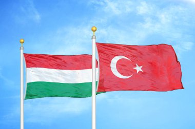 Macaristan ve Türkiye bayrak direkleri ve mavi bulutlu arka planda iki bayrak