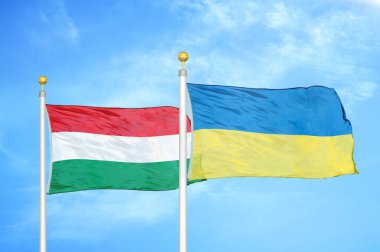 Macaristan ve Ukrayna bayrak direkleri ve mavi bulutlu arka planda iki bayrak