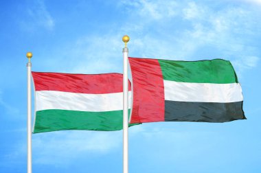 Macaristan ve Birleşik Arap Emirlikleri bayrak direkleri ve mavi bulutlu arka planda iki bayrak