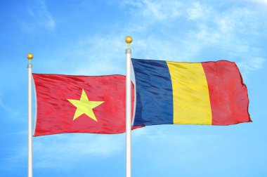 Vietnam ve Çad bayrak direkleri üzerinde iki bayrak ve mavi bulutlu arka plan