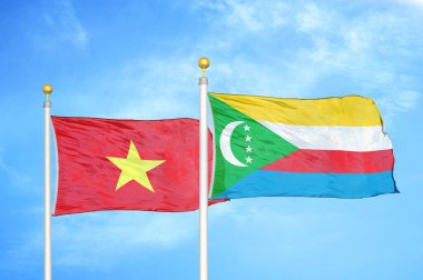 Vietnam ve Komoros bayrak direkleri üzerinde iki bayrak ve mavi bulutlu arka plan