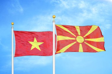 Vietnam ve Kuzey Makedonya bayrak direkleri ve mavi bulutlu arka planda iki bayrak