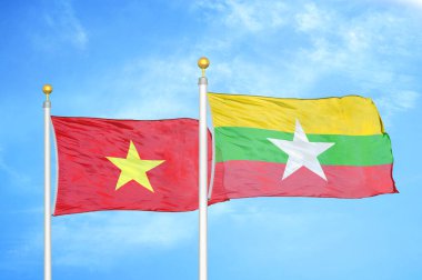 Vietnam ve Myanmar bayrak direkleri ve mavi bulutlu arka planda iki bayrak