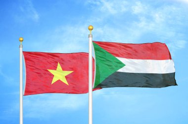 Vietnam ve Sudan bayrak direkleri üzerinde iki bayrak ve mavi bulutlu arka plan