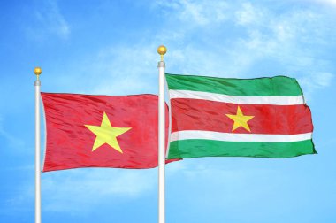 Vietnam ve Surinam bayrak direkleri üzerinde iki bayrak ve mavi bulutlu arka plan