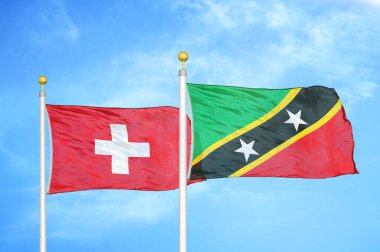 İsviçre ve Saint Kitts ve Nevis bayrak direğinde iki bayrak ve mavi bulutlu gökyüzü arkaplanı