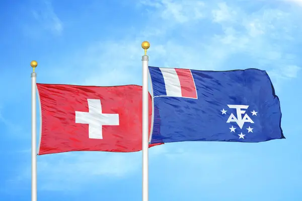 スイスとフランスの南と南極の土地旗竿と青い空の背景に2つの旗 — ストック写真