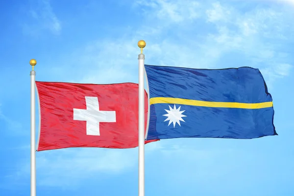 旗竿にスイスとナウルの2つの旗と青空の背景 — ストック写真