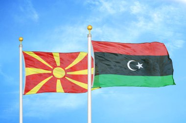 Kuzey Makedonya ve Libya bayrak direkleri ve mavi bulutlu arka planda iki bayrak