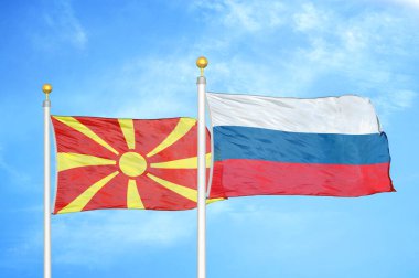 Kuzey Makedonya ve Rusya bayrak direkleri ve mavi bulutlu arka planda iki bayrak