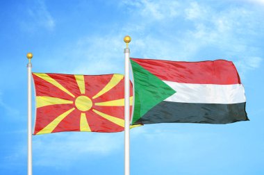 Kuzey Makedonya ve Sudan bayrak direkleri ve mavi bulutlu arka planda iki bayrak