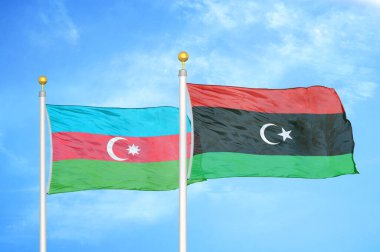 Azerbaycan ve Libya bayrak direkleri ve mavi bulutlu arka planda iki bayrak