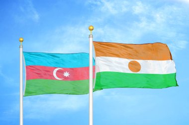 Azerbaycan ve Nijer bayrak direkleri ve mavi bulutlu arka planda iki bayrak