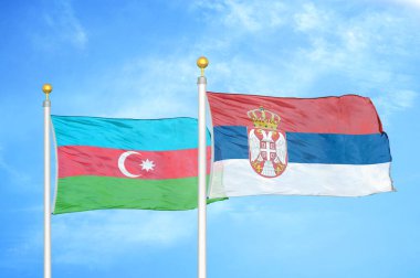 Azerbaycan ve Sırbistan bayrak direkleri ve mavi bulutlu arka planda iki bayrak