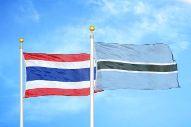 Tayland ve Botswana bayrak direğinde iki bayrak ve mavi bulutlu arka plan
