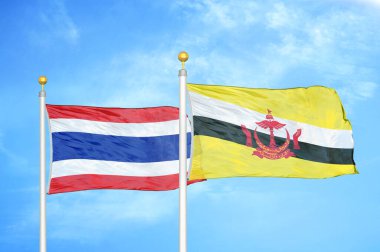 Tayland ve Brunei Darussalam bayrak direkleri üzerinde iki bayrak ve mavi bulutlu arka plan