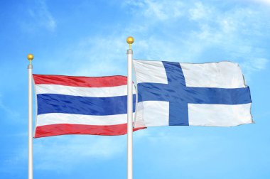 Tayland ve Finlandiya bayrak direkleri ve mavi bulutlu arka planda iki bayrak