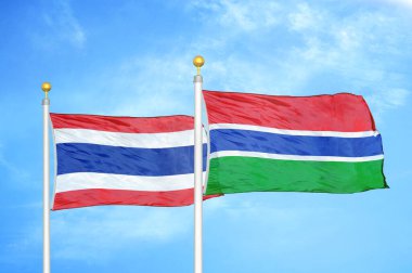 Tayland ve Gambiya bayrak direkleri üzerinde iki bayrak ve mavi bulutlu arka plan