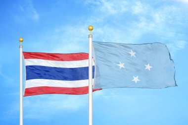 Tayland ve Mikronezya bayrak direkleri üzerinde iki bayrak ve mavi bulutlu arka plan