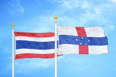 Tayland ve Hollanda Antilleri bayrak direkleri üzerinde iki bayrak ve mavi bulutlu arka plan