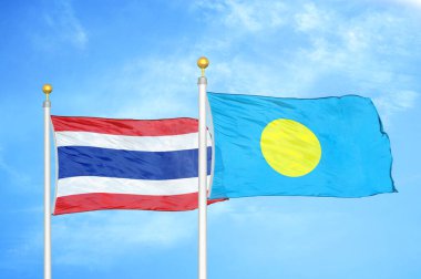 Tayland ve Palau bayrak direkleri üzerinde iki bayrak ve mavi bulutlu arka plan