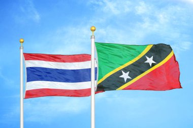 Tayland ve Saint Kitts ve Nevis bayrak direğinde iki bayrak ve mavi bulutlu bir arka plan