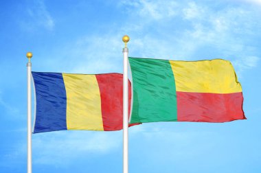 Romanya ve Benin bayrak direkleri ve mavi bulutlu arka plan üzerinde iki bayrak