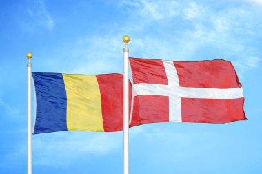 Romanya ve Danimarka bayrak direkleri ve mavi bulutlu arka planda iki bayrak dikti