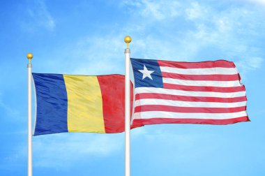 Romanya ve Liberya bayrak direkleri ve mavi bulutlu arka planda iki bayrak